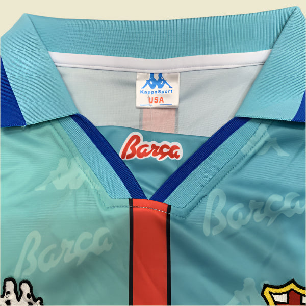 Teal Barcelona 96/97 away shirt with red and blue accents, featuring 'Barca' branding, on a textured gray background.