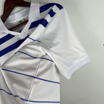 White Porto 85/86 away shirt with blue stripes on a hanger against a neutral background