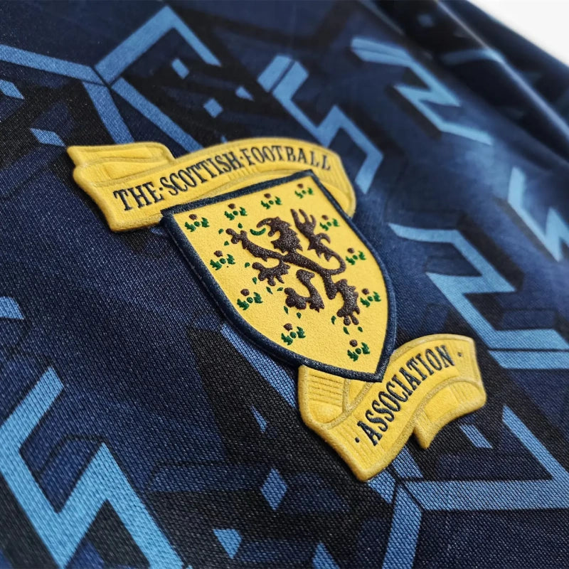 Close-up of a Scottish Football Association logo on a Scotland 1992 home shirt with a blue and black pattern.