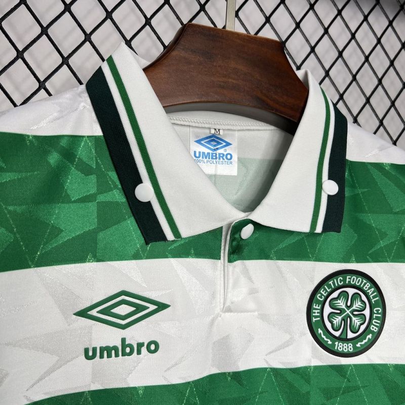 Green and white Celtic 89-91 home shirt  with Umbro and Celtic FC logos on a hanger against a chain-link fence background.