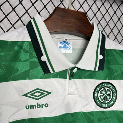 Green and white Celtic 89-91 home shirt  with Umbro and Celtic FC logos on a hanger against a chain-link fence background.