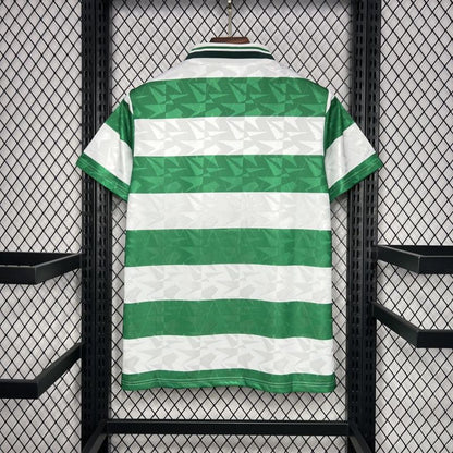 Green and white striped Celtic 89-91 home shirt  on a hanger against a black grid background