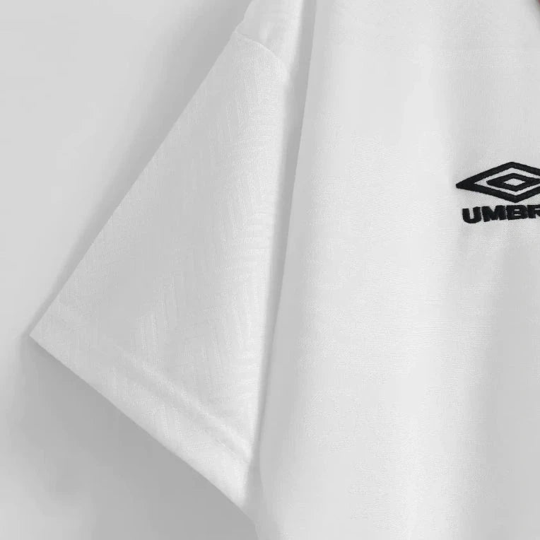 Close-up of a white England 1994 home shirt with Umbro logo on a light gray background