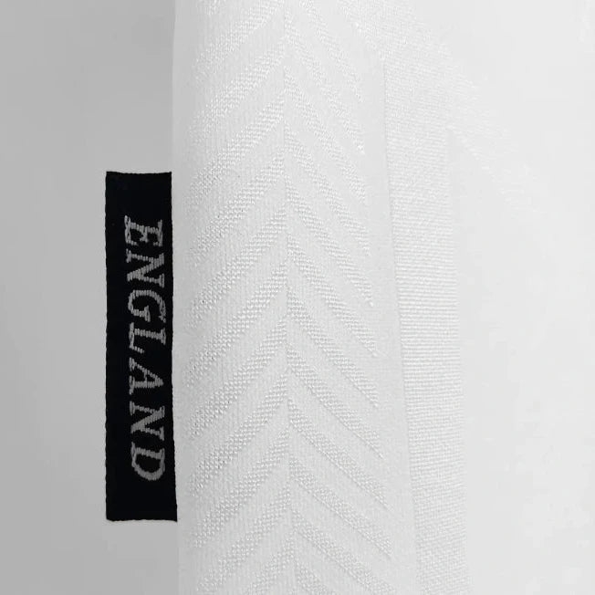 Close-up of a white England 1994 home shirt with 'ENGLAND' label on a gray background
