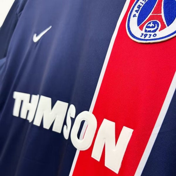 Close-up of a PSG 02/03 home shirt with 'Thompson' branding and a logo