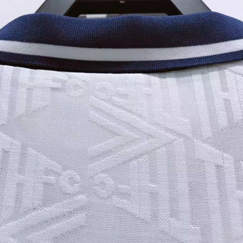 Close-up of a Tottenham 91-93 home shirt with a blue collar and white patterned design.