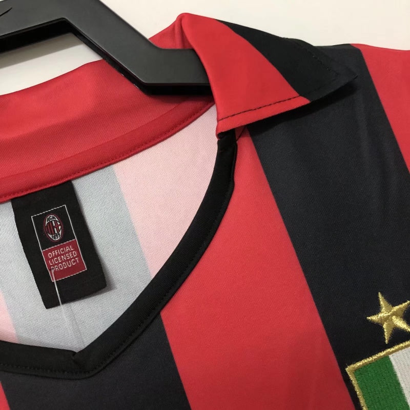 Red and black Ac Milan 88/89 home shirt with a gold star and scudetto emblem on a hanger.