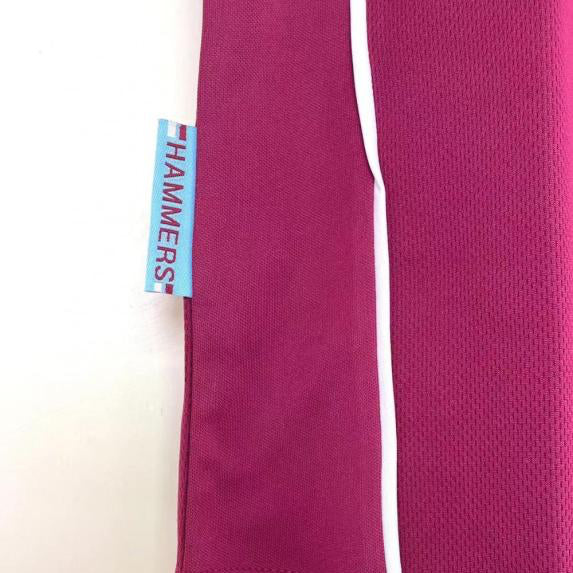 Close-up of a West Ham 99/01 home shirt with a visible brand tag on a white background