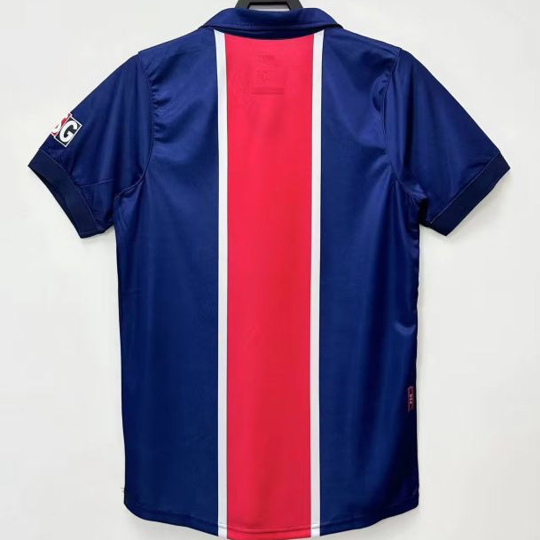 Blue psg 98/99 home shirt  with red and white stripe on a hanger against a white background
