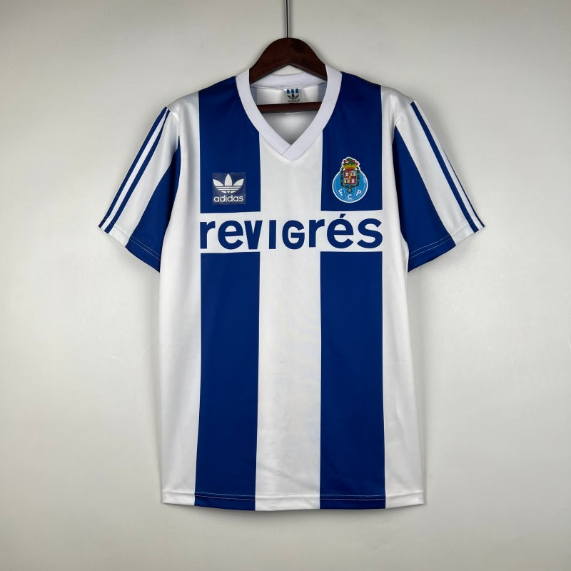 Blue and white striped Porto 90-93 home shirt with Adidas logo on a hanger against a light gray background