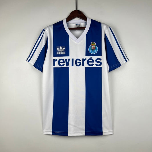 Blue and white striped Porto 90-93 home shirt with Adidas logo on a hanger against a light gray background