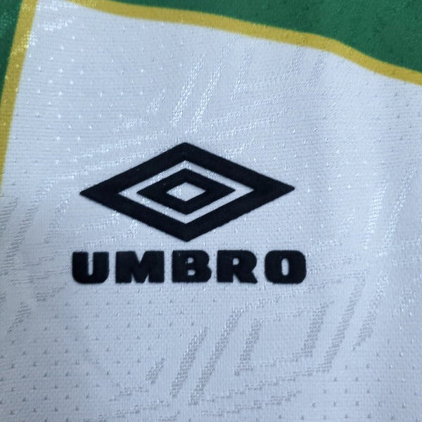 Umbro logo on a 93-95 Celtic away shirt  with green and white background