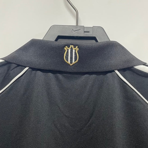 Newcastle 00/01 away shirt with a logo on a hanger against a white background