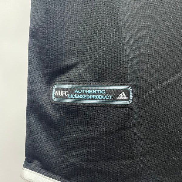 Black Newcastle 00/01 away shirt with Adidas logo and 'N. U. F. C.' text on a white background