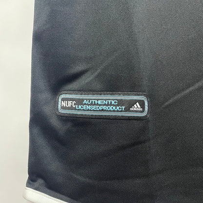 Black Newcastle 00/01 away shirt with Adidas logo and 'N. U. F. C.' text on a white background