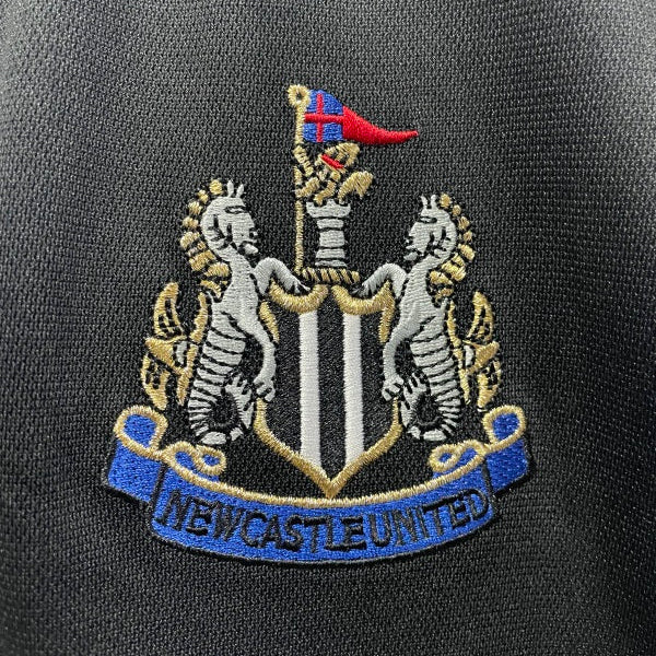 Embroidered Newcastle United logo on a dark background