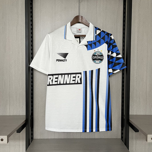 White Gremio 94/95 away shirt with blue and black accents hanging on a rack.