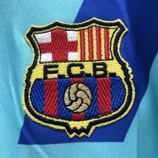 Close-up of FC Barcelona logo on a Barcelona 92-95 away shirt  with blue and red colors.