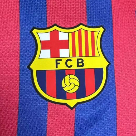 Close-up of a Barcelona 11/12 home shirt with a prominent logo featuring 'FCB'