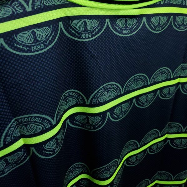 Close-up of a Celtic 99/00 Away shirt with green and black patterns on a dark background