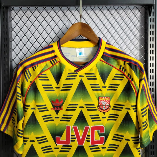 Vintage Arsenal 01-03 away shirt with geometric pattern and 'JVC' branding on a hanger.