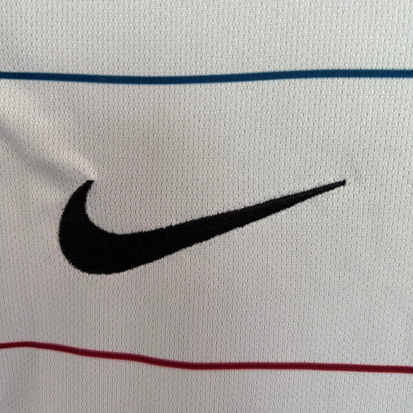Close-up of a Nike logo on a Barcelona 03-05 away shirt with horizontal lines.