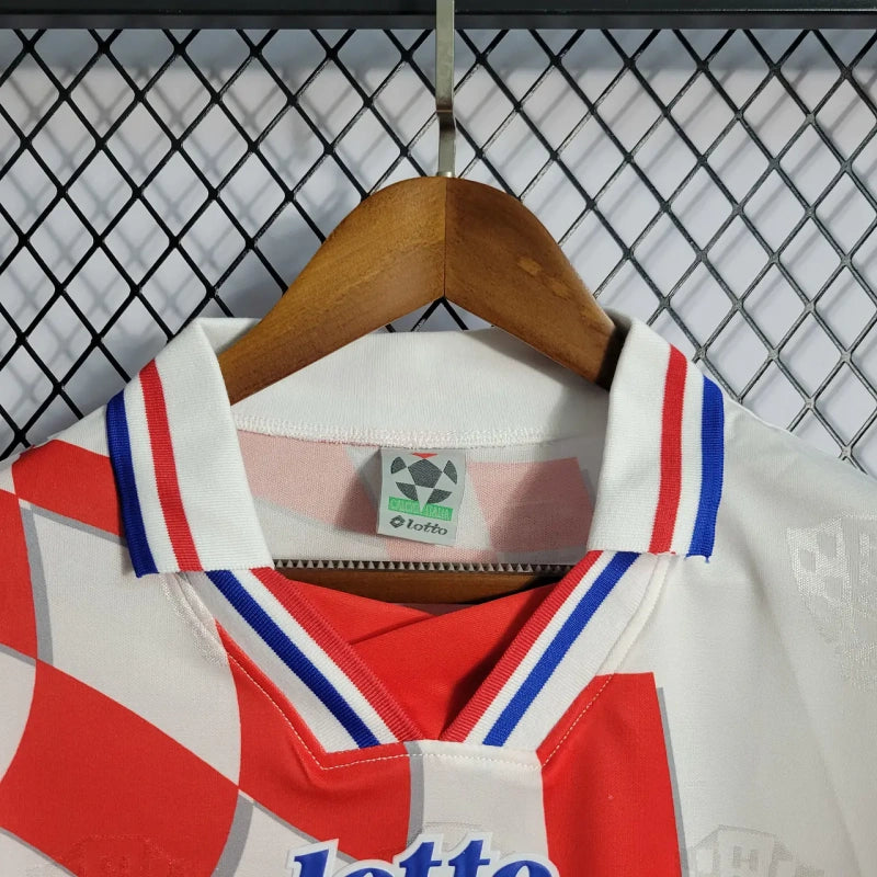 White Croatia 1998 home shirt  with red and blue accents on a hanger against a wire mesh background