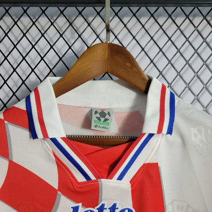 White Croatia 1998 home shirt  with red and blue accents on a hanger against a wire mesh background