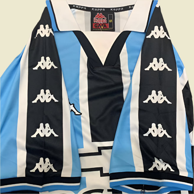 Kappa Gremio 2000 home shirt  with blue, black, and white design on a textured gray background