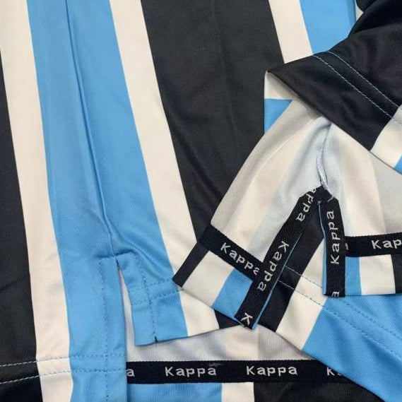 Kappa branded Gremio 2000 home shirt  with blue, black, and white stripes on a textured surface