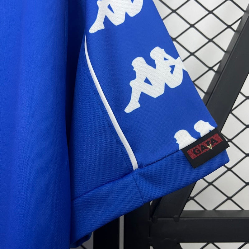 Blue Juventus 99/00 away shirt  with white logo and brand tag on a black and white checkered background