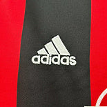 Close-up of a Ac Milan 00-02 home shirt  with Adidas logo and a red and black design.