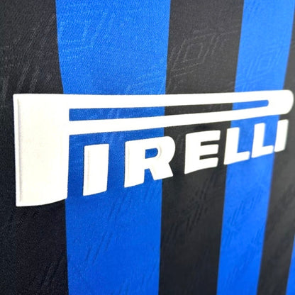 Close-up of a Inter Milan 95/96 home shirt  with Pirelli logo on a black and blue striped background