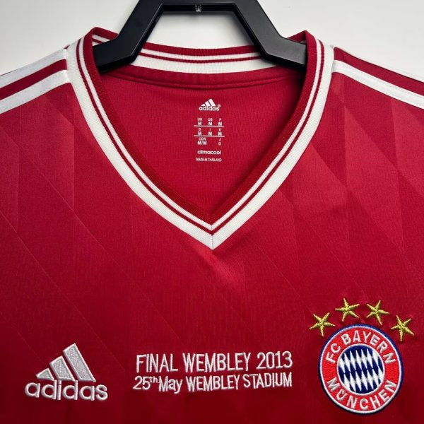 Red Bayern Munich 13 champions league final shirt with branding on a hanger against a white background