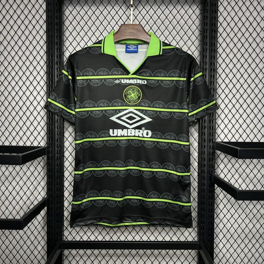 Black Celtic 98/99 away shirt with green accents hanging on a rack