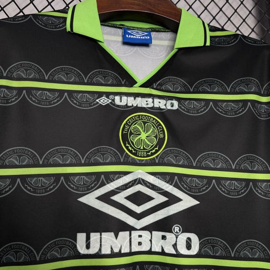 Black Celtic 98/99 away shirt with green accents and Umbro branding on a hanger.