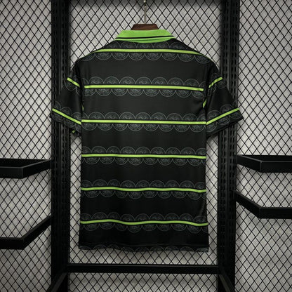 Black Celtic 98/99 away shirt shirt with green stripes hanging on a rack.