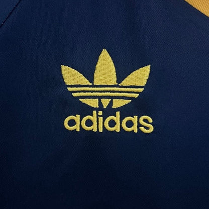 Close-up of an Adidas logo on a dark blue Roma 91/92 third shirt with yellow accents.