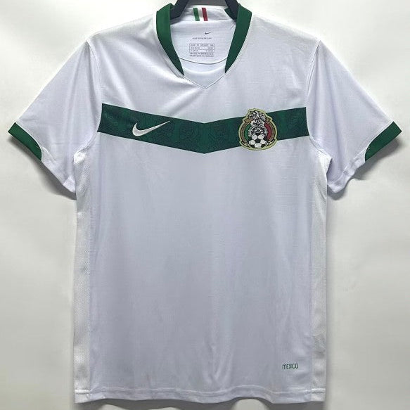 White Mexico 2006 away shirt with green accents on a hanger against a white background