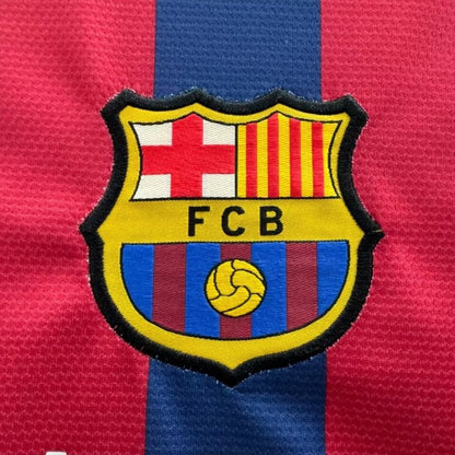 Close-up of FC Barcelona logo on a red and blue striped Barcelona 13/14 home shirt 