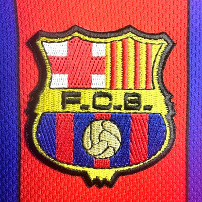 F.C. Barcelona logo on a red and blue striped Barcelona 97/98 home shirt