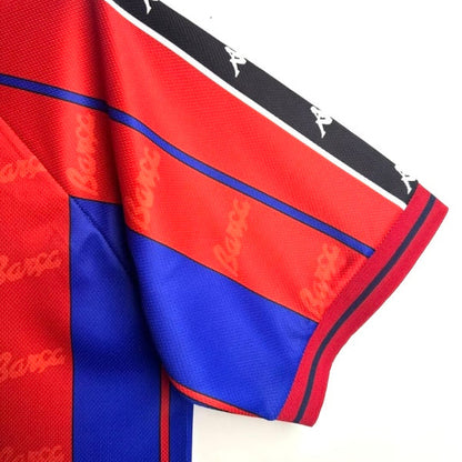 Close-up of a red and blue Barcelona 97/98 home shirt with branding on a white background