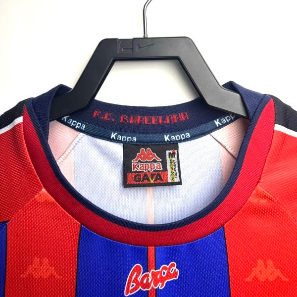 Barcelona 97/98 home shirt with visible brand logos on a hanger against a white background