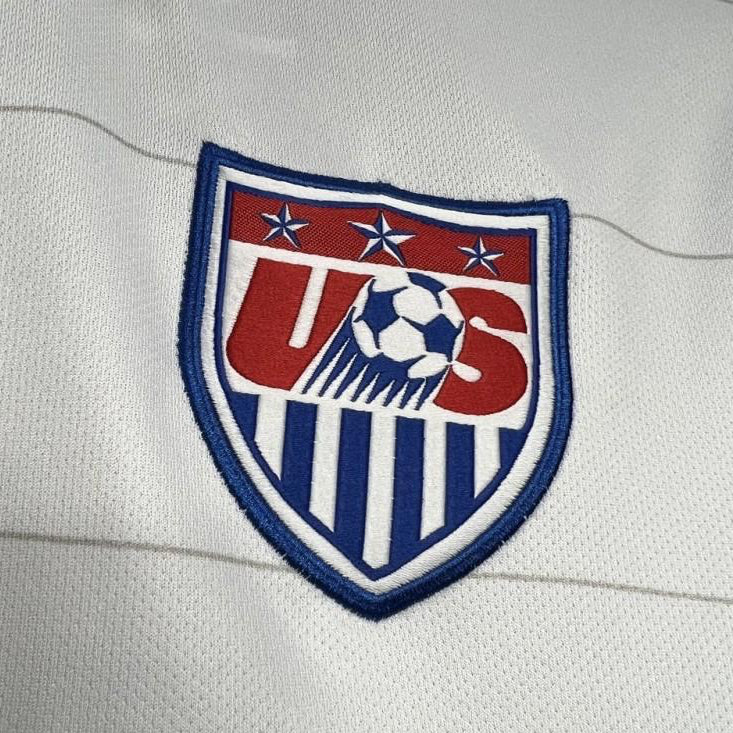 Embroidered logo on a USA 2014 home shirt with red, white, and blue colors.
