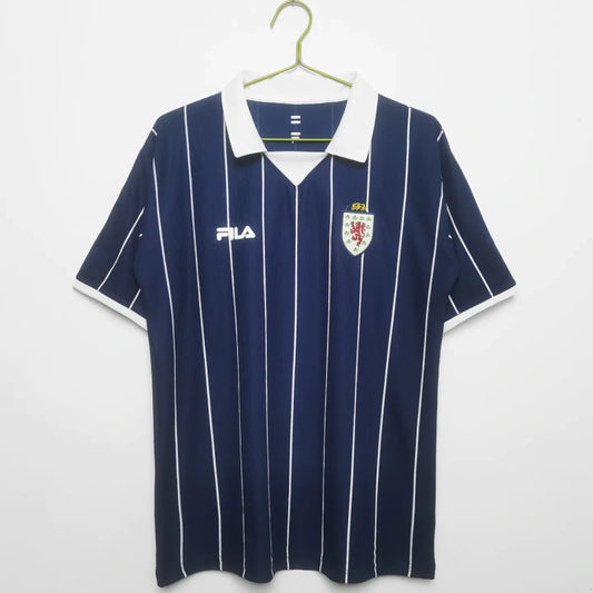 Navy blue Scotland 2002 home shirt with white stripes and logos on a hanger against a white background