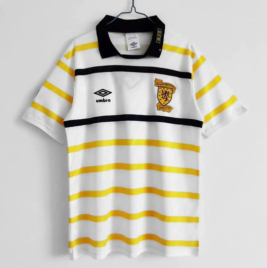 White Scotland 1988 away shirt with yellow stripes and Umbro logo on a gray background