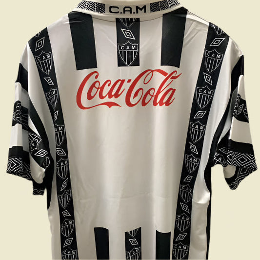 Black and white striped Mineiro 94/95 home shirt with Coca-Cola logo on a gray background