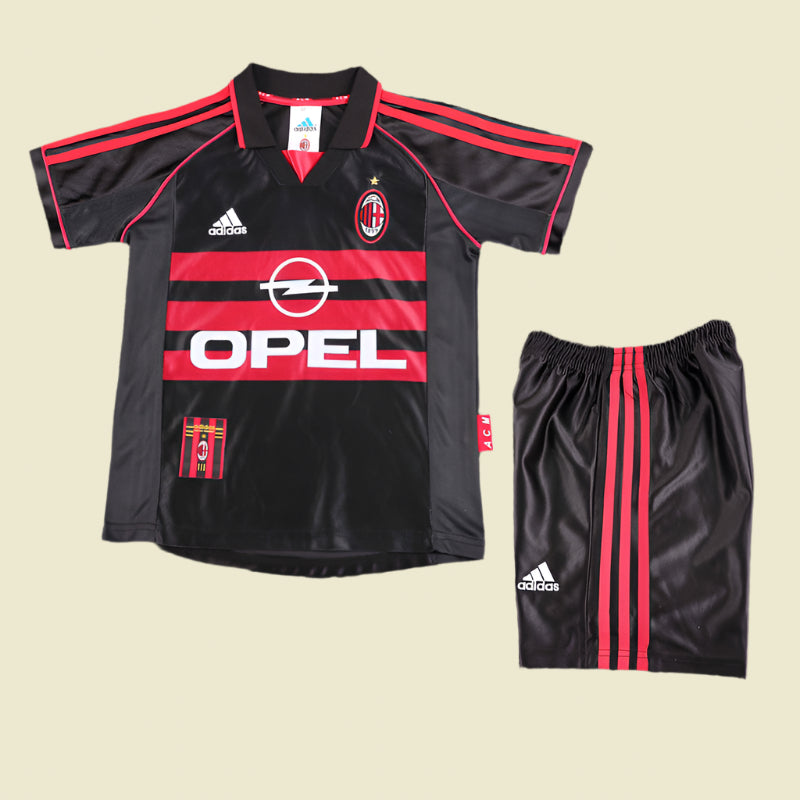 Black and red ac Milan 98/99 third kids kit with Opel logo and Adidas branding on a textured surface
