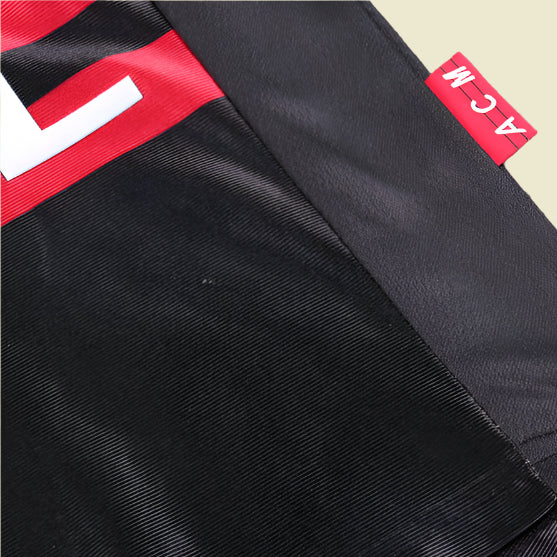 ac Milan 98/99 third kids kit  with a red and white logo tag on a textured surface