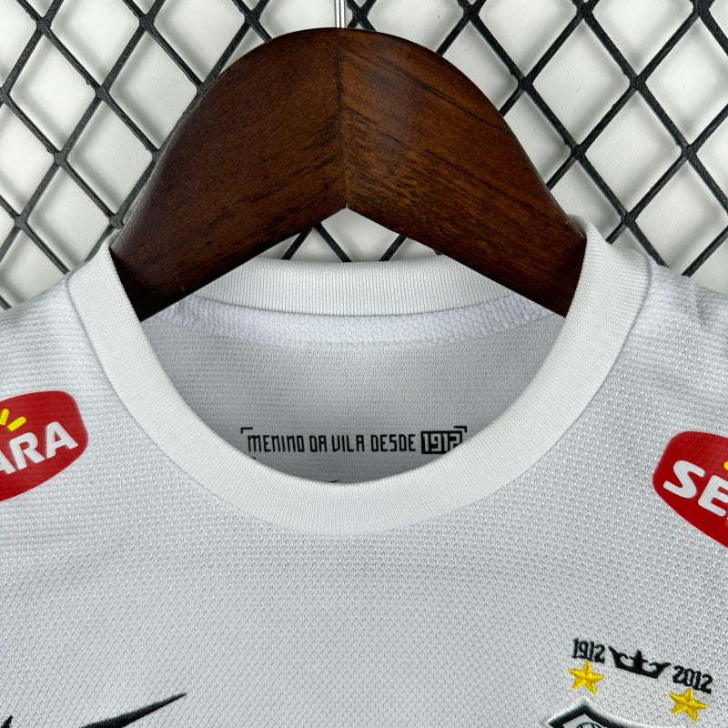 White Santos 2012 centenary home kids kit with brand logos on a hanger against a wire mesh background